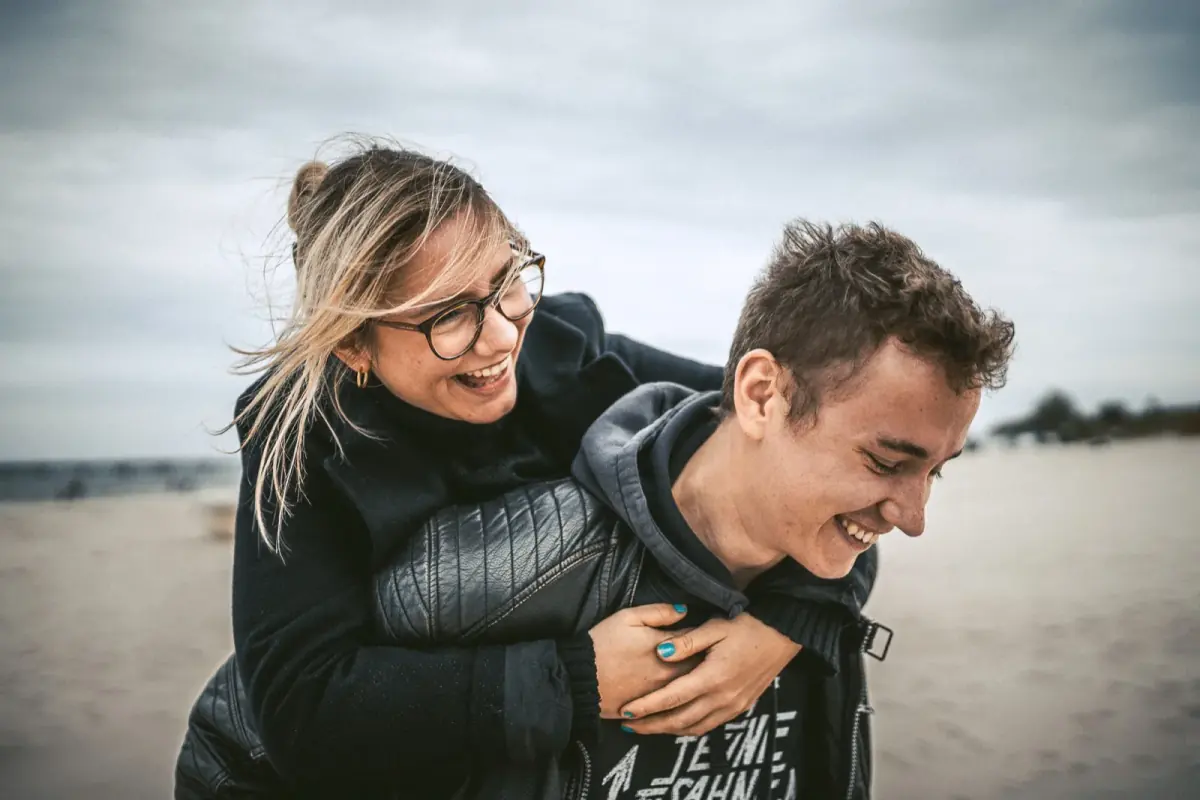Erik carrying Darja piggyback on a beach